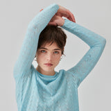 Knitted top in light blue with eyelet pattern in a light quality with wool. CordellMD short o-neck has a relaxed and cropped fit with long sleeves with wavy trims. The model is 175 cm and wears a size
