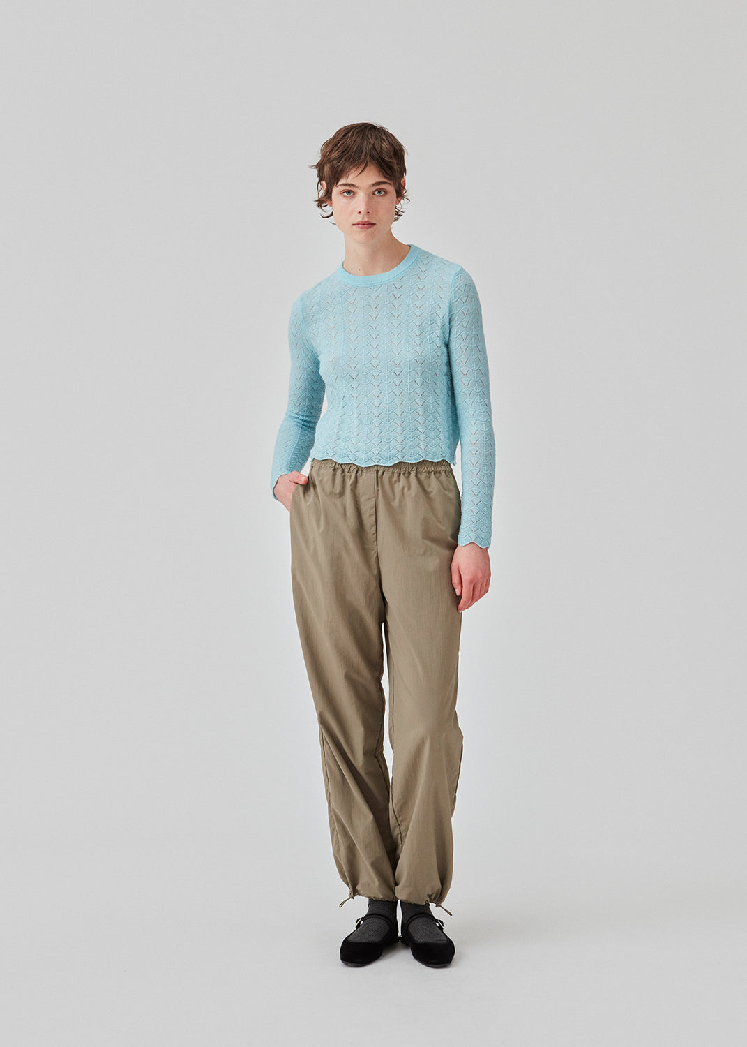 Knitted top in light blue with eyelet pattern in a light quality with wool. CordellMD short o-neck has a relaxed and cropped fit with long sleeves with wavy trims. The model is 175 cm and wears a size