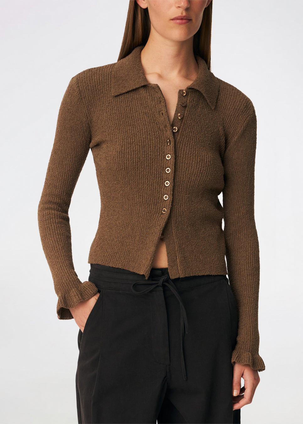 Feminine rib-knit cardigan with elegant details. Corneliamd cardigan is designed in a fitted silhouette with a classic collar, full button-front closure, and delicate ruffle trims at the cuffs. The soft rib-knit enhances the flattering fit, making it a versatile wardrobe staple that can be worn buttoned up as a knit top or layered open over a camisole or dress.