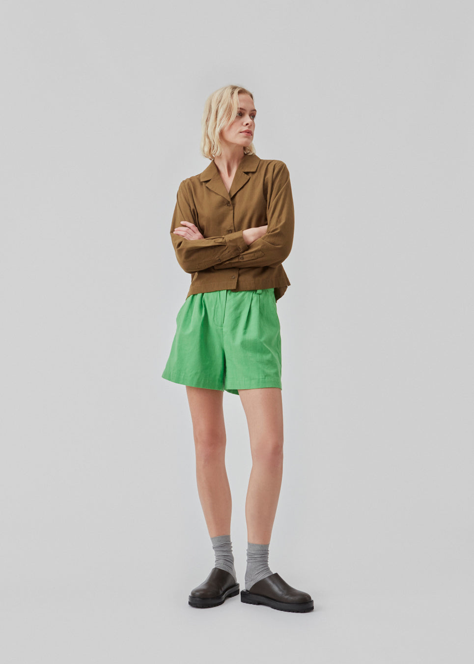 Cotton shirt in dark forest with a boxy fit and cropped length. CydneyMD shirt has long sleeves, a resort collar, and a button closure in front.  The model is 177 cm and wears a size S/36.