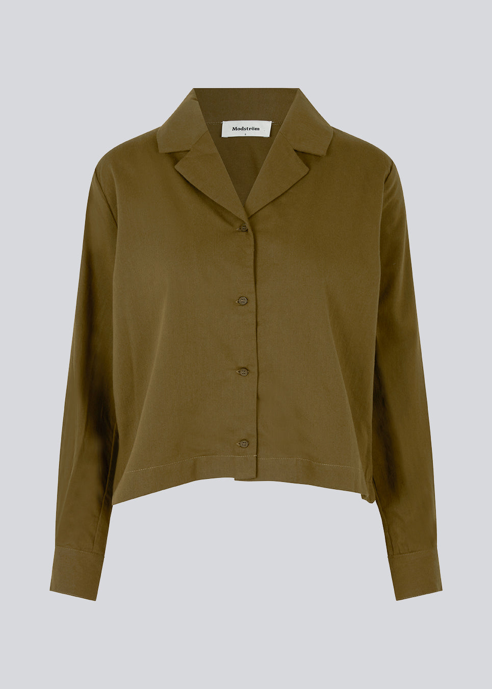 Cotton shirt in dark forest with a boxy fit and cropped length. CydneyMD shirt has long sleeves, a resort collar, and a button closure in front.  The model is 177 cm and wears a size S/36.