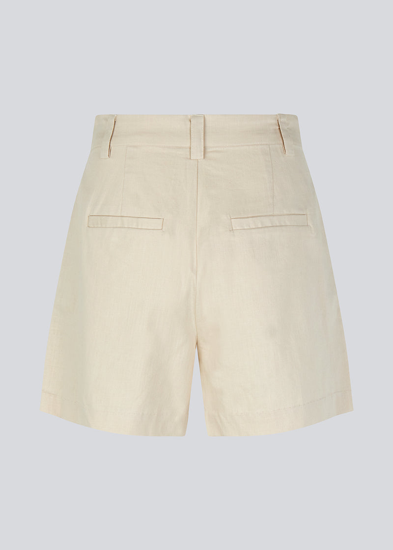 Cotton shorts in beige with wide legs. CydneyMD shorts has a tailormade look with pleats in front and paspoil pockets in back.