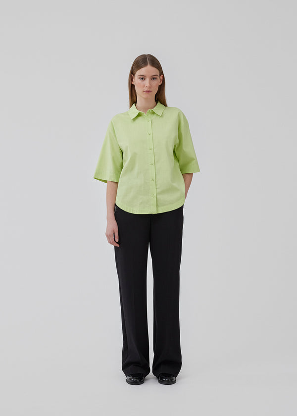 Short, oversized shirt in cotton. CydneyMD ss shirt has a collar, button closure in front, and rounded hems at the bottom. Dropped shoulders and short sleeves. The model is 175 cm and wears a size S/36.
