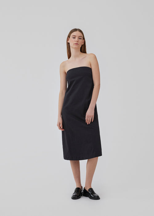 Strapless dress with an A-line shape with midi length. CydneyMD tube dress is designed in cotton with a silicone band at the top, and a hidden zipper at one side. The model is 175 cm and wears a size S/36.