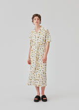 Shirt dress in the color Flower Sparkles in woven fabric with resort collar, short sleeves, button closure in front, and tie belt at the waist. Lined. The model is 177 cm and wears a size S/36.
