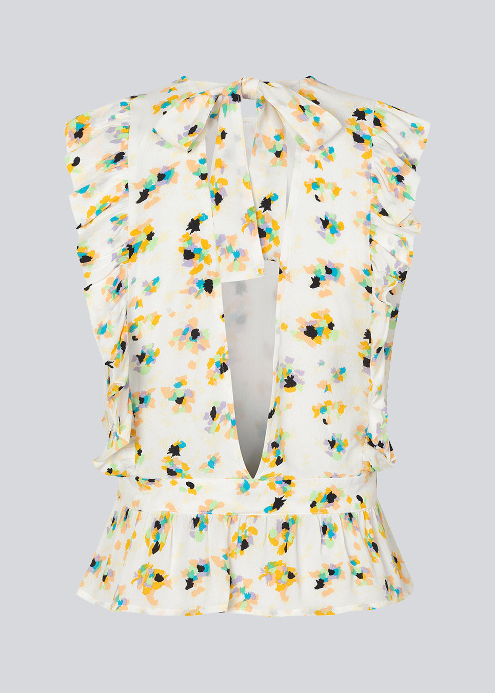 Sleeveless top in the color Flower Sparkles with a high neck and a slight peplum effect. DafneMD print top has ruffled details over the shoulders and at the bottom, along with an opening in the back with ties. The model is 177 cm and wears a size S/36.