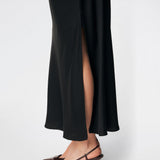 DanillaMD Dress is a long satin dress with an elegant, figure-hugging silhouette. The design features a straight neckline, thin straps and draped detailing at the side, creating a soft fall. The open back with delicate crossing straps adds a feminine touch. Style it with heels and simple accessories for special occasions. The model is 175 cm tall and is wearing a size S/36.