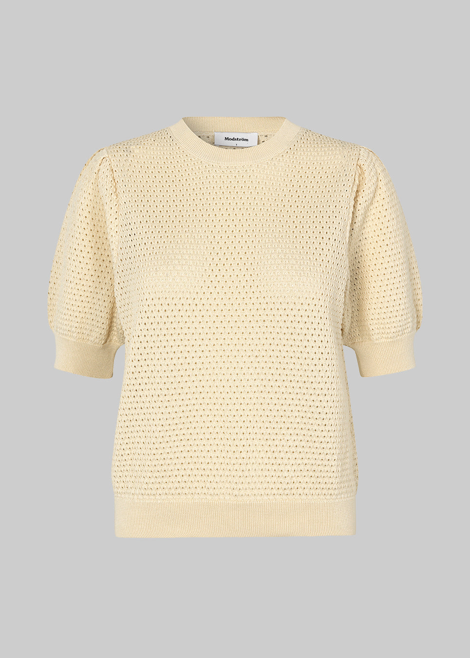 DariaMD o-neck is an open-knitted jumper in beige with short puff sleeves and a round neck. Ribbed trimmings at the bottom, neckline, and cuffs. The model is 177 cm and wears a size S/36.