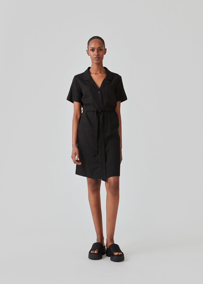 Relaxed shirt dress in black cut from a linen blend. DarrelMD dress has a resort collar, short sleeves, buttons in front, and a wide tiebelt at the waist. The model is 177 cm and wears a size S/36.