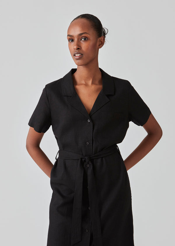 Relaxed shirt dress in black cut from a linen blend. DarrelMD dress has a resort collar, short sleeves, buttons in front, and a wide tiebelt at the waist. The model is 177 cm and wears a size S/36.