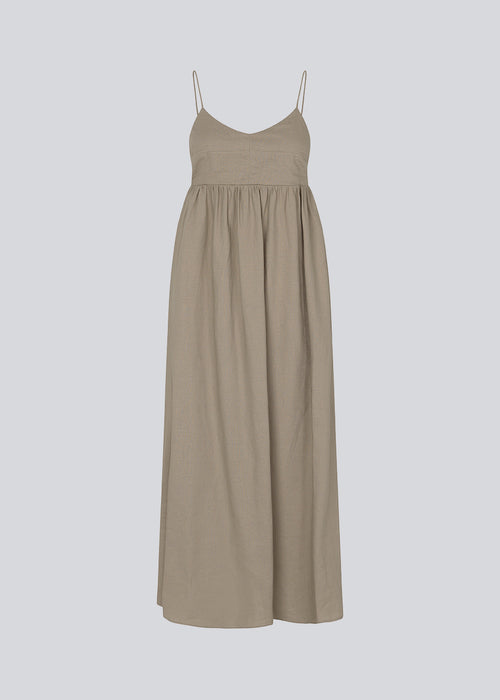 DarrelMD long dress in beige is designed in a linen mix with a figure-hugging top with a v-neckline, spaghetti straps with adjustable ties on the back, and a loose skirt. Lined. The model is 177 cm and wears a size S/36.