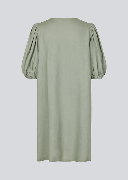 Mini dress in light green with a loose fit and puff sleeves with elastic in the end. DarrelMD dress has an opening in the front with a button closure.