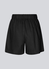 Shorts in black in a relaxed fit, wide legs, and an elasticated waistband. DarrelMD shorts are crafted from a linen material. The model is 177 cm and wears a size S/36.