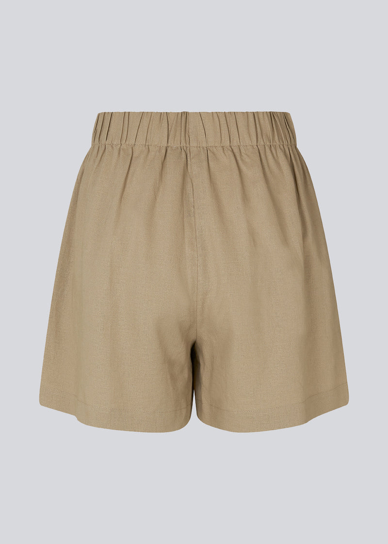 Shorts in the color Dune in a relaxed fit, wide legs, and an elasticated waistband. DarrelMD shorts are crafted from a linen material. The model is 177 cm and wears a size S/36.