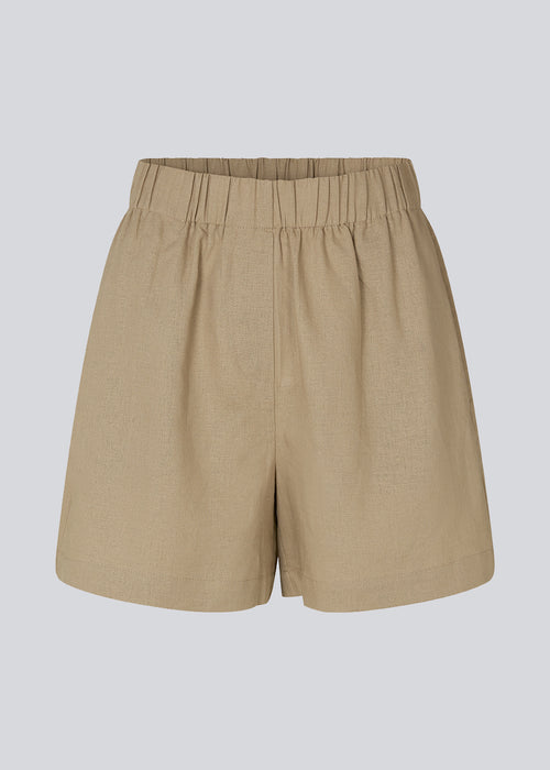 Shorts in the color Dune in a relaxed fit, wide legs, and an elasticated waistband. DarrelMD shorts are crafted from a linen material. The model is 177 cm and wears a size S/36.