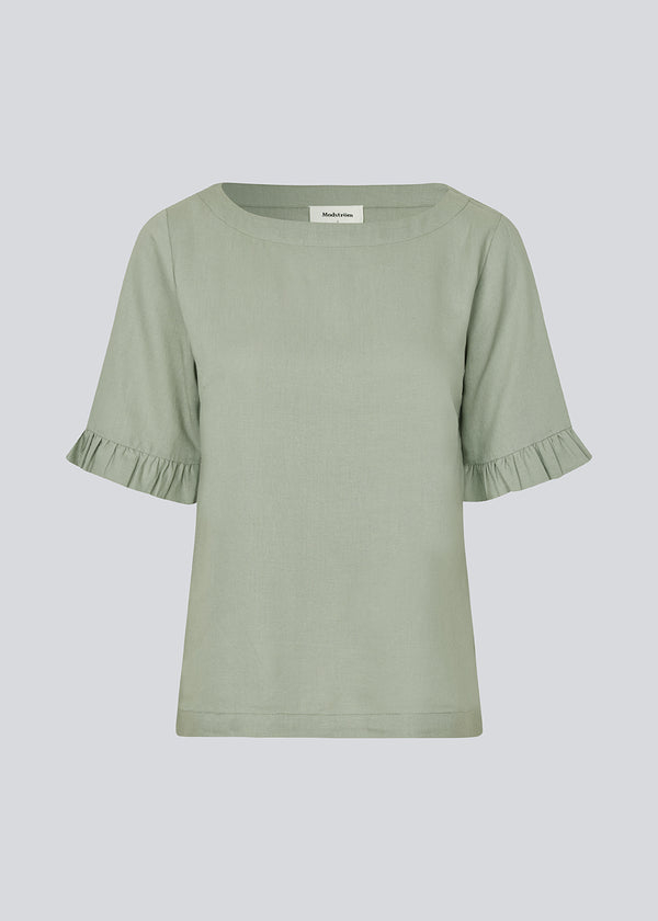 Loose shirt in light green with short sleeves. DarrelMD SS top has a wide neckline and a ruffle detail on the sleeves.