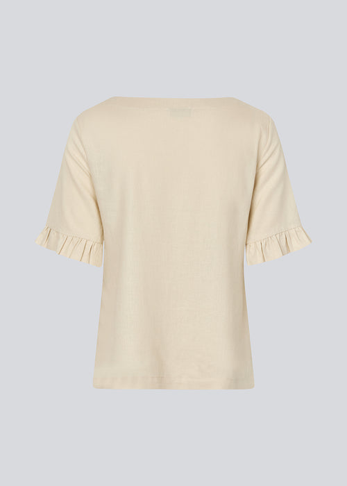 Loose shirt in beige with short sleeves. DarrelMD SS top has a wide neckline and a ruffle detail on the sleeves.