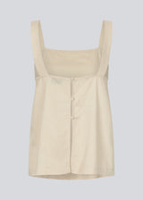 Linen top in beige with wide straps and a loose fit. DarrelMD top has a slit in the back and is closed with three buttons.