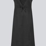 Short black linen dress with an A-line silhouette. DaynaMD dress is sleeveless, and features a deep v-neckline with cut-out details and ties. The model is 177 cm and wears a size S/36.