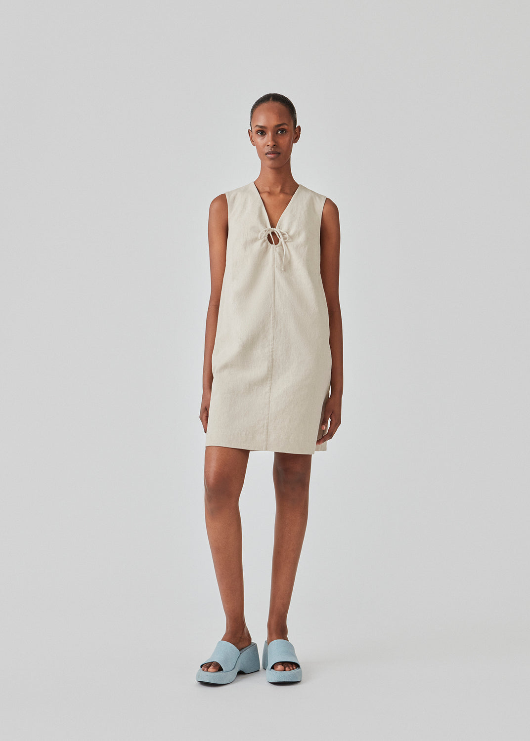 Short dress in a linen blend with an A-line silhouette. DaynaMD dress is sleveless, and features a deep v-neckline with cut out details and ties. The model is 177 cm and wears a size S/36.