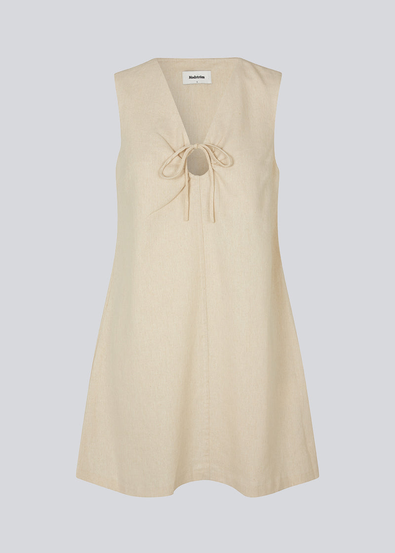Short dress in a linen blend with an A-line silhouette. DaynaMD dress is sleveless, and features a deep v-neckline with cut out details and ties. The model is 177 cm and wears a size S/36.