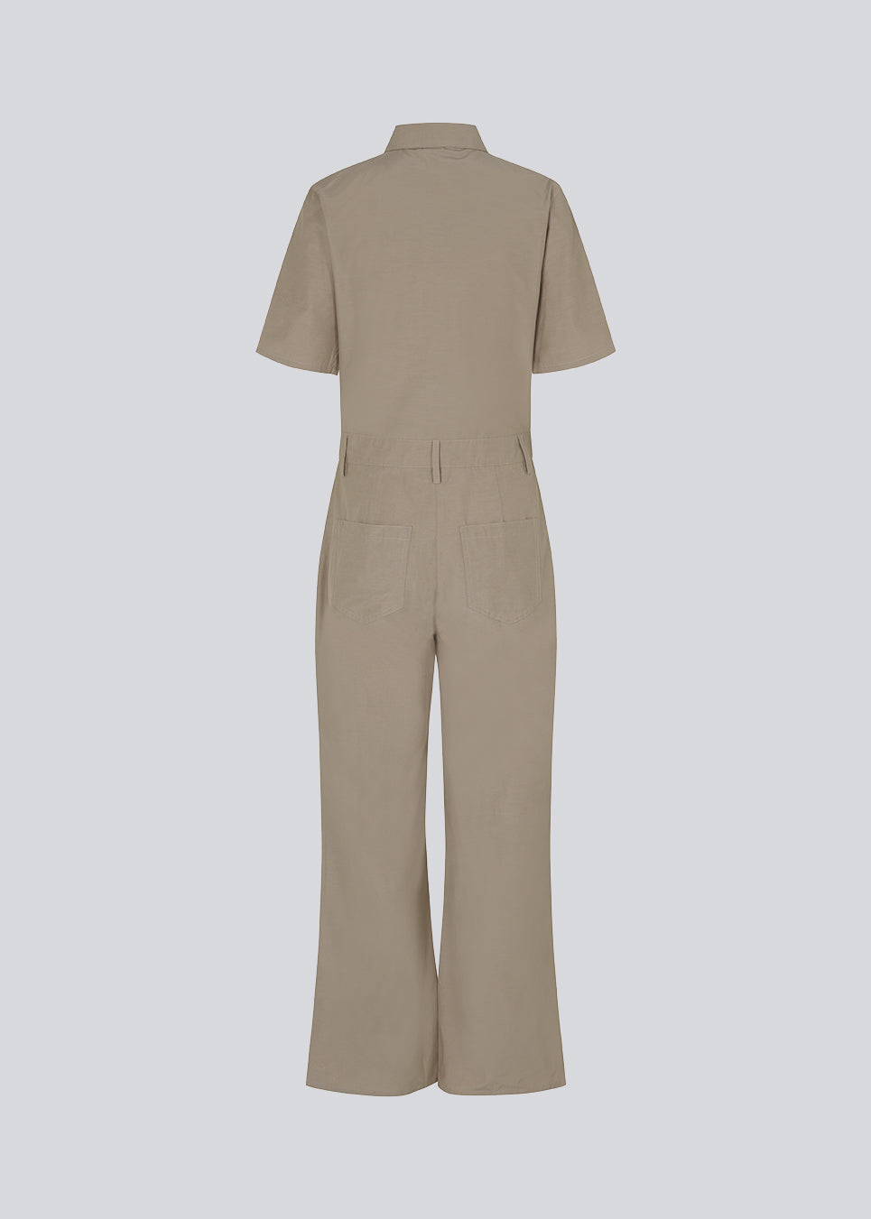 Jumpsuit in a crispy cotton blend with long, wide legs. DedeMD jumpsuit has short sleeves, collar, and zipper down the front. Belt straps at the waist. The model is 177 cm and wears a size S/36.