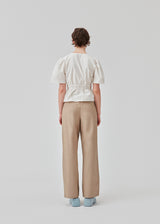 Suit pants in a cotton blend with a relaxed silhouette and wide legs. DeenMD pants have a medium waist, zip fly, and pleats at the front. The model is 177 cm and wears a size S/36.