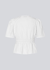 White top made from a cotton mix with short, slightly puffed, sleeves, and a deep v-neckline. DeenMD top has a flattering ruched detail below the chest and at the waist. The model is 177 cm and wears a size S/36.