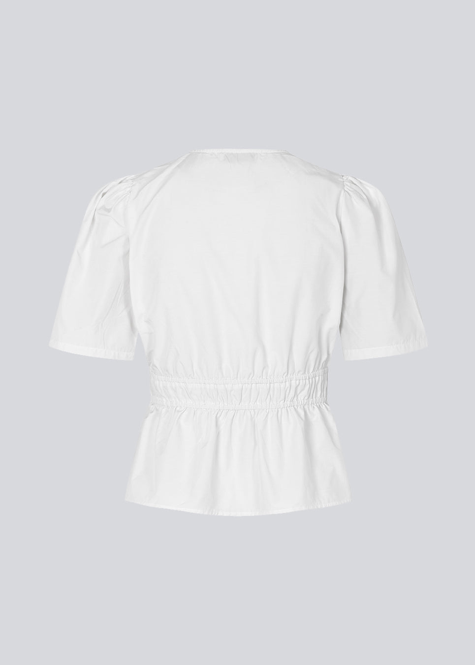 White top made from a cotton mix with short, slightly puffed, sleeves, and a deep v-neckline. DeenMD top has a flattering ruched detail below the chest and at the waist. The model is 177 cm and wears a size S/36.