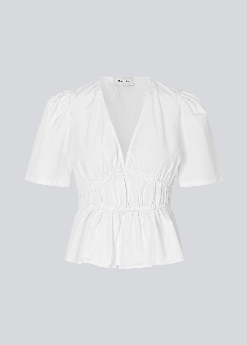 White top made from a cotton mix with short, slightly puffed, sleeves, and a deep v-neckline. DeenMD top has a flattering ruched detail below the chest and at the waist. The model is 177 cm and wears a size S/36.