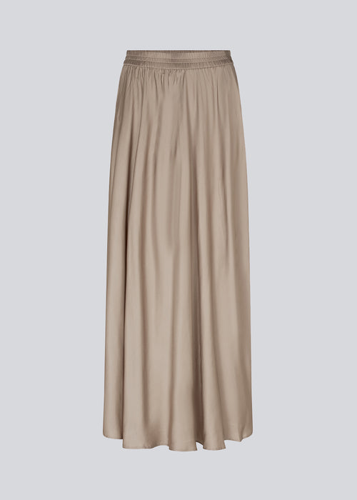 Long beige skirt with wide skirt. DevanMD skirt is designed in a shiny satin material with elasticated medium waist. The model is 177 cm and wears a size S/36.
