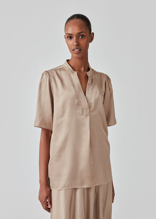Beige shirt in a satin quality with a relaxed shape. DevanMD top has a v-neckline with open collar and short puff sleeves. The model is 177 cm and wears a size S/36.