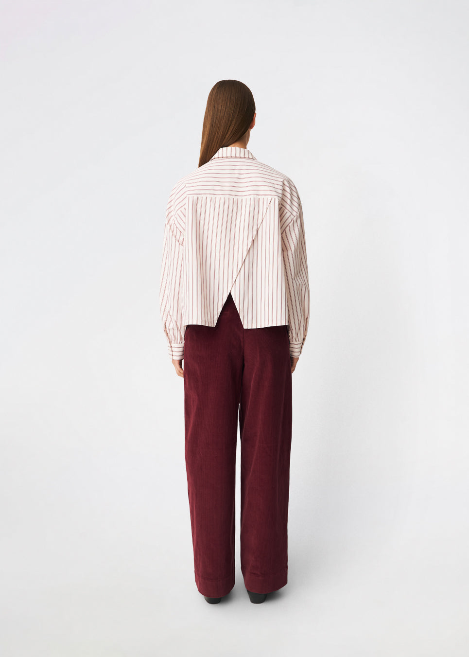 The Dilanmd Stripe Shirt is a classic striped shirt with a relaxed oversized fit. Designed with a traditional collar, button closure, and wide cuffs, it is finished with a distinctive overlapping back slit that adds a modern twist. A versatile wardrobe staple that can be worn on its own or layered effortlessly over everyday essentials.