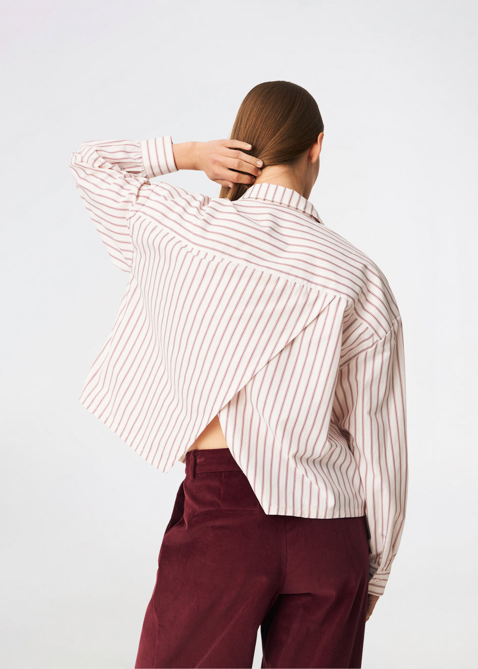 The Dilanmd Stripe Shirt is a classic striped shirt with a relaxed oversized fit. Designed with a traditional collar, button closure, and wide cuffs, it is finished with a distinctive overlapping back slit that adds a modern twist. A versatile wardrobe staple that can be worn on its own or layered effortlessly over everyday essentials.