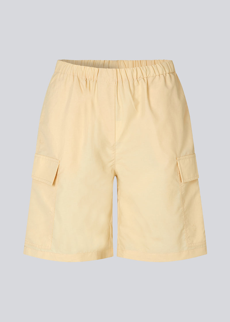 Cargo shorts in the color Pale Sun in nylon with wide legs. DilaraMD shorts have an elasticated waistband and two large patch pockets on the sides. The model is 177 cm and wears a size S/36.