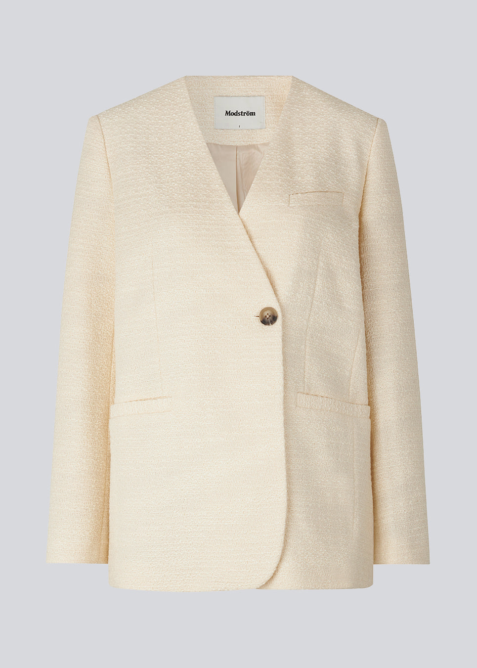 DimeMD blazer is designed in a textured cotton blend with lining. The blazer is collarless but has an asymmetrical wrap detail with a single visible button. The model is 177 cm and wears a size S/36.  Style the blazer with matching shorts: DimeMD shorts.