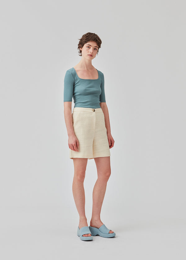 Shorts in a textured cotton blend. DimeMD shorts have wide legs cutting mid-thigh, an elasticated waist in the back, and zip fly and button closure in front. The model is 177 cm and wears a size S/36.  Styles shorts with matching blazer: DImeMD blazer.