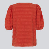 DinoMD top in red is designed in a seersucker material with a relaxed fit. The top has a v-neckline and short puff sleeves with elasticated cuffs. 