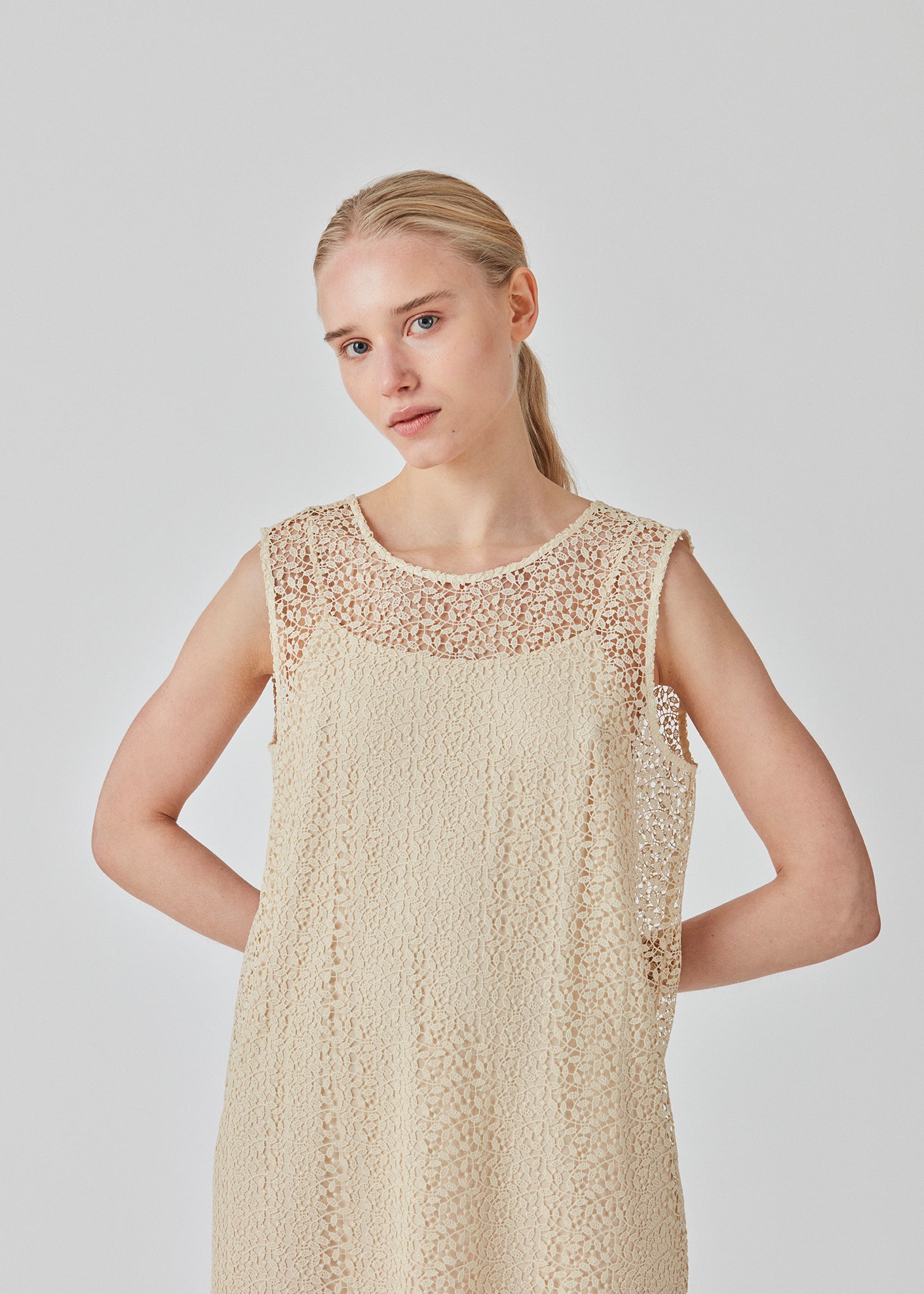 Sleeveless dress in a short length cut from a lace material. DionaMD dress has a round neck in front and a deep neckline in the back. The model is 177 cm and wears a size S/36.