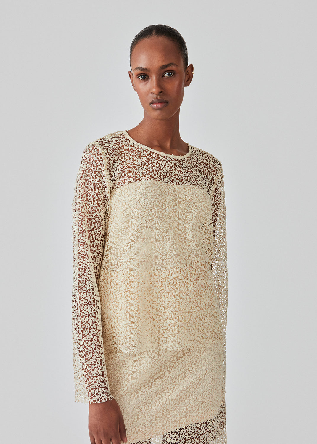 Top designed for a regular fit and long sleeves in an elegant lace material. DionaMD top has a round neck and button closure in the back. The top is slightly transparent. The model is 177 cm and wears a size S/36.