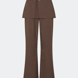 The Dodomd Pants feature a straight-leg silhouette with an integrated skirt overlay that creates a modern, statement look. A slim waist strap with a metal buckle adds a refined finishing touch, while the clean tailoring makes them easy to style. Pair them with the matching Dodomd Top or a simple knit for an elevated everyday outfit.