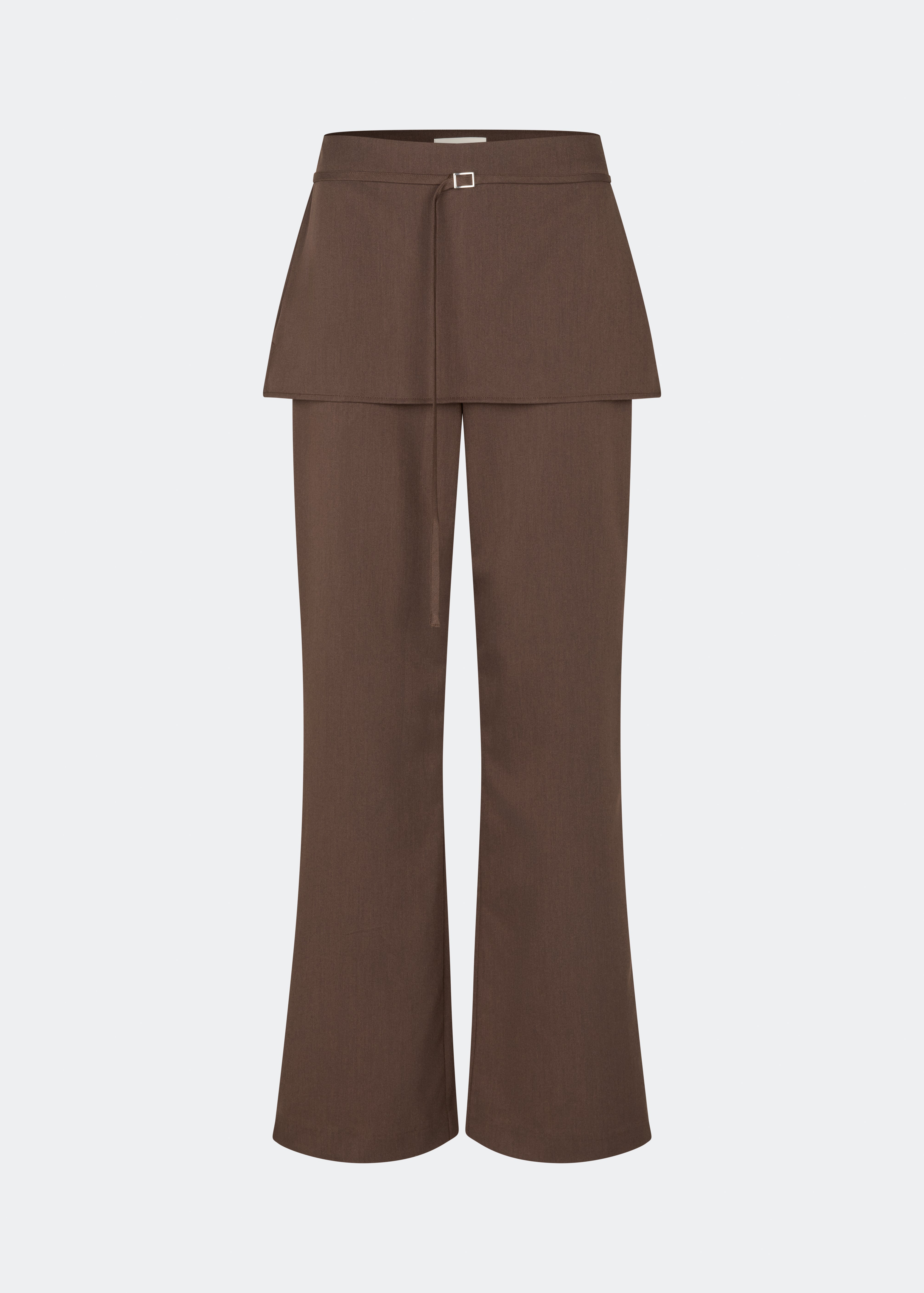 The Dodomd Pants feature a straight-leg silhouette with an integrated skirt overlay that creates a modern, statement look. A slim waist strap with a metal buckle adds a refined finishing touch, while the clean tailoring makes them easy to style. Pair them with the matching Dodomd Top or a simple knit for an elevated everyday outfit.