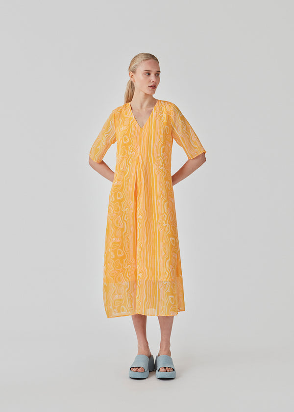 Long dress designed for a loose fit in a recycled material. DonteMD long print dress has short wide sleeves, v-neck, and a pleat in front. Lined. The model is 177 cm and wears a size S/36.