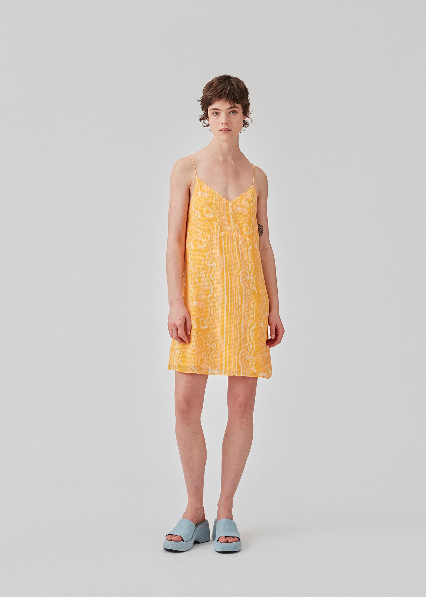 DonteMD print strap dress is a short dress with a slim fit, a v-neckline, ruched detail in the back, cutline at the waist, and narrow adjustable straps. Lined. The model is 177 cm and wears a size S/36.