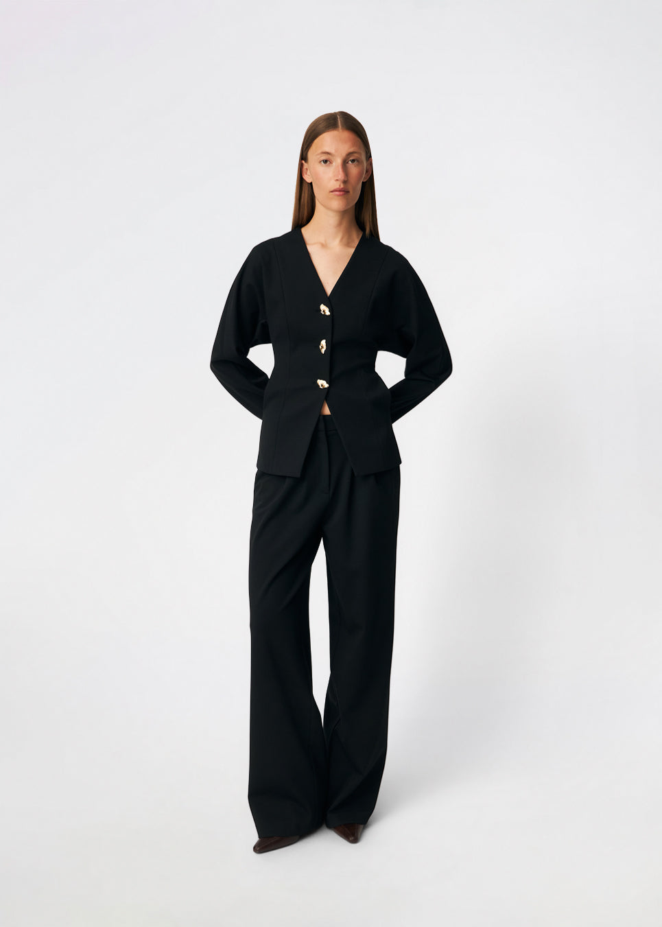 The Doritmd Blazer is a feminine tailored blazer with a clean collarless neckline and a fitted silhouette. Sculptural gold-tone buttons add a refined statement, while the shaped panels accentuate the waist for a flattering fit. Wear it with the matching trousers or layer it over a dress for a modern, sophisticated look.