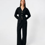 The Doritmd Blazer is a feminine tailored blazer with a clean collarless neckline and a fitted silhouette. Sculptural gold-tone buttons add a refined statement, while the shaped panels accentuate the waist for a flattering fit. Wear it with the matching trousers or layer it over a dress for a modern, sophisticated look.