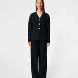 The Doritmd Blazer is a feminine tailored blazer with a clean collarless neckline and a fitted silhouette. Sculptural gold-tone buttons add a refined statement, while the shaped panels accentuate the waist for a flattering fit. Wear it with the matching trousers or layer it over a dress for a modern, sophisticated look.