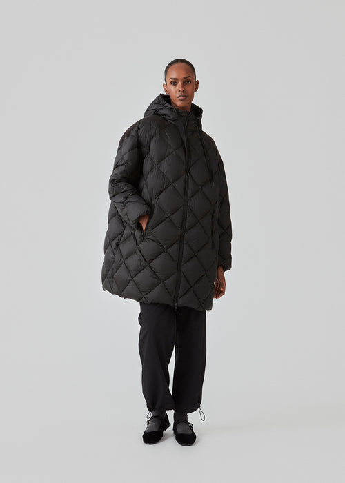 EddaMD jacket is a quilted down jacket with a normal fit. EddaMD jacket has a high collar with hood with wide pulls. Strong zippers down the front and on the pockets. The model is 175 cm and wears a size S/36.