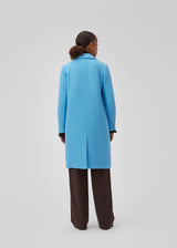 Double-breasted coat with lapels and buttons in front. EdinMD coat has a midi length with long sleeves, front pockets with a flap and single back vent. Lined. The model is 175 cm and wears a size S/36.