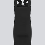 Short fitted black dress in an elastic material. EmiliaMD dress has a cool detailed metal ring at the chest and wide straps.
